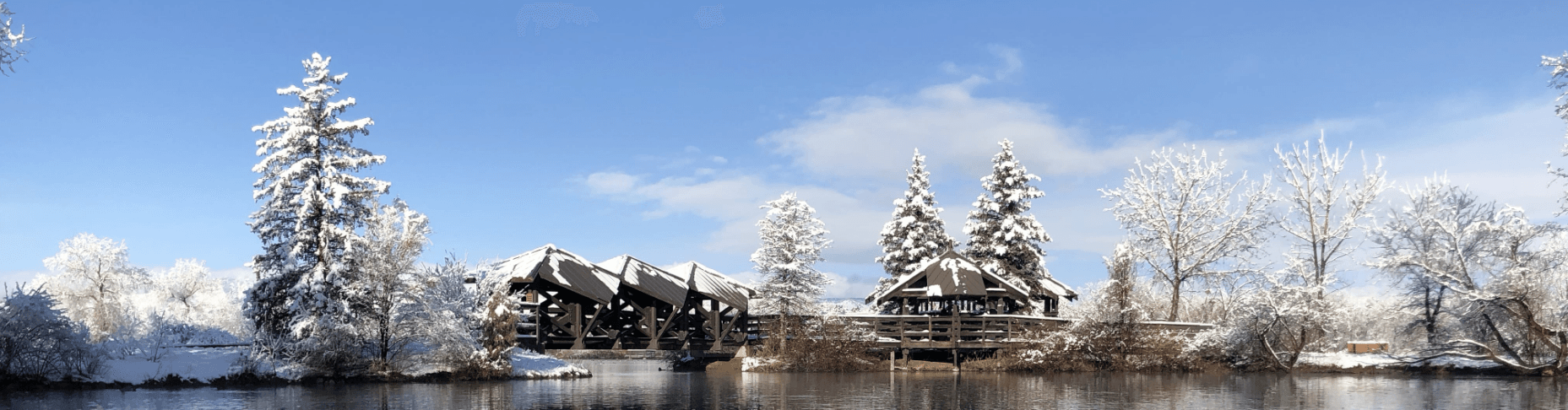 snowy lake view with a building across the lake